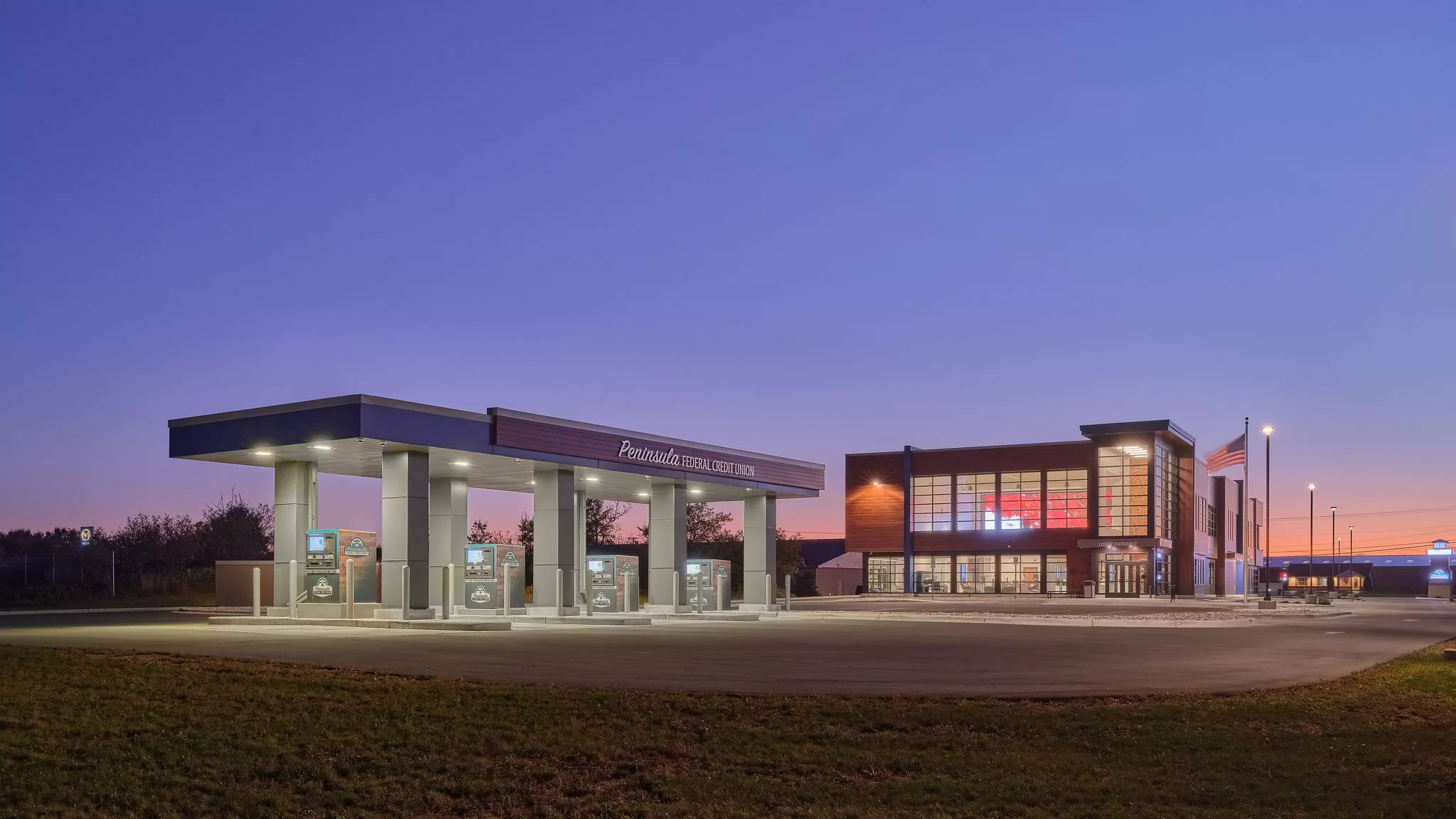 Picture of the front of the main headquarters of PFCU in Escanaba, showing the ITMs and building